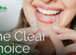 smiling female holding clear aligners