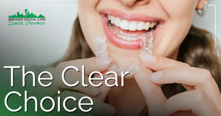 smiling female holding clear aligners