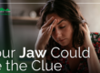 woman in pain holding head and neck